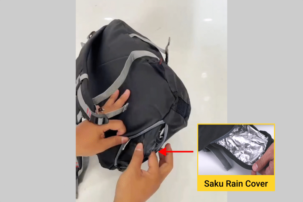 Tangan mengeluarkan rain cover dari bawah tas Inflico BA325IFS, ditunjukkan tanda panah dan text overlay 'Saku Rain Coverā.