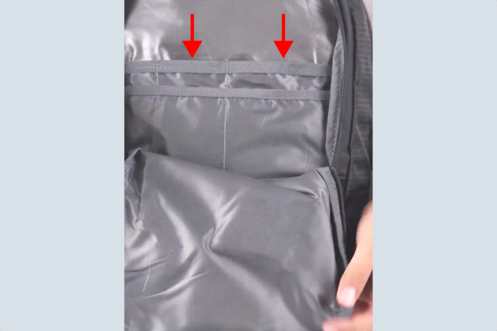 Slot organizer kompartemen depan tas Outvin TL 795 untuk menyimpan barang kecil supaya lebih rapi, ditunjukkan tanda panah.