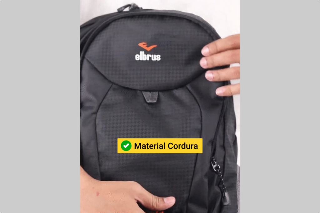 Sepasang tangan memegang ransel Outvin TL 795, menunjukkan bahannya yang terbuat dari bahan Cordura yang awet, kuat, ringan.